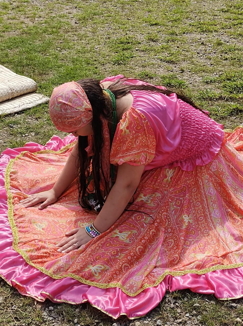 Vidente Samanta em momento ritualístico com vestes rosadas ao ar livre
