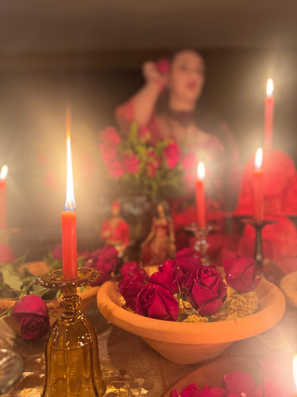 Altar com rosas vermelhas e velas acesas em atmosfera acolhedora